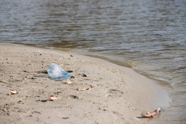 plaj kum üzerinde parçalanmış pet tek kullanımlık plastik şişe. Plastik kirliliği