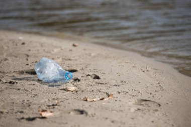 plaj kum üzerinde parçalanmış pet tek kullanımlık plastik şişe. Plastik kirliliği