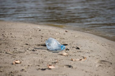 plaj kum üzerinde parçalanmış pet tek kullanımlık plastik şişe. Plastik kirliliği
