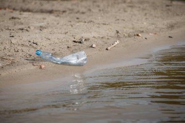 plaj kum üzerinde parçalanmış pet tek kullanımlık plastik şişe. Plastik kirliliği