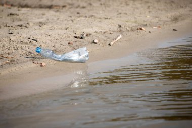 plaj kum üzerinde parçalanmış pet tek kullanımlık plastik şişe. Plastik kirliliği