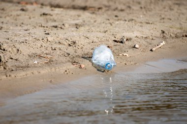 plaj kum üzerinde parçalanmış pet tek kullanımlık plastik şişe. Plastik kirliliği