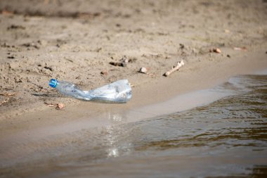 plaj kum üzerinde parçalanmış pet tek kullanımlık plastik şişe. Plastik kirliliği