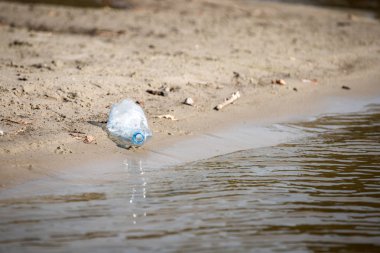 plaj kum üzerinde parçalanmış pet tek kullanımlık plastik şişe. Plastik kirliliği