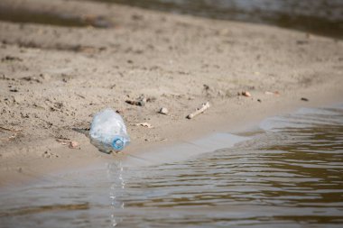 plaj kum üzerinde parçalanmış pet tek kullanımlık plastik şişe. Plastik kirliliği