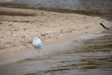 plaj kum üzerinde parçalanmış pet tek kullanımlık plastik şişe. Plastik kirliliği
