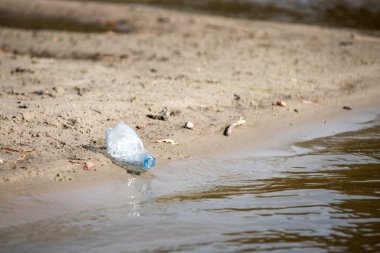 plaj kum üzerinde parçalanmış pet tek kullanımlık plastik şişe. Plastik kirliliği