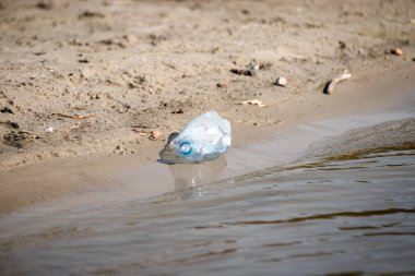 plaj kum üzerinde parçalanmış pet tek kullanımlık plastik şişe. Plastik kirliliği