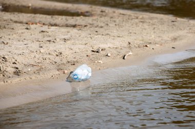 plaj kum üzerinde parçalanmış pet tek kullanımlık plastik şişe. Plastik kirliliği