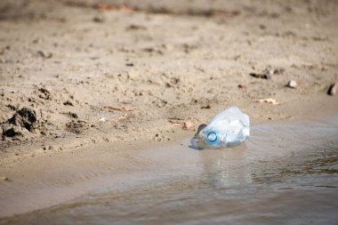 plaj kum üzerinde parçalanmış pet tek kullanımlık plastik şişe. Plastik kirliliği
