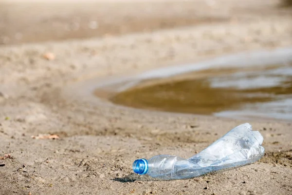 plaj kum üzerinde parçalanmış pet tek kullanımlık plastik şişe. Plastik kirliliği