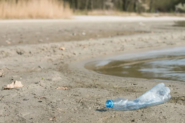 plaj kum üzerinde parçalanmış pet tek kullanımlık plastik şişe. Plastik kirliliği