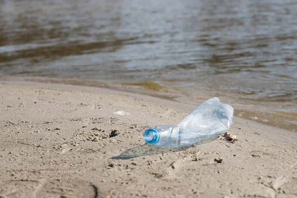 plaj kum üzerinde parçalanmış pet tek kullanımlık plastik şişe. Plastik kirliliği