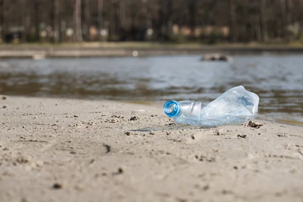 smashed pet disposable plastic bottle on beach sand. Plastic pollution