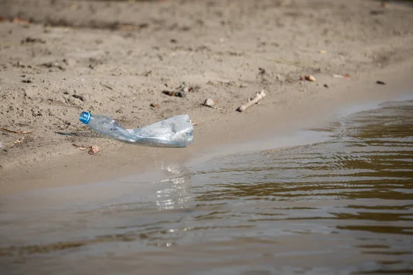 plaj kum üzerinde parçalanmış pet tek kullanımlık plastik şişe. Plastik kirliliği