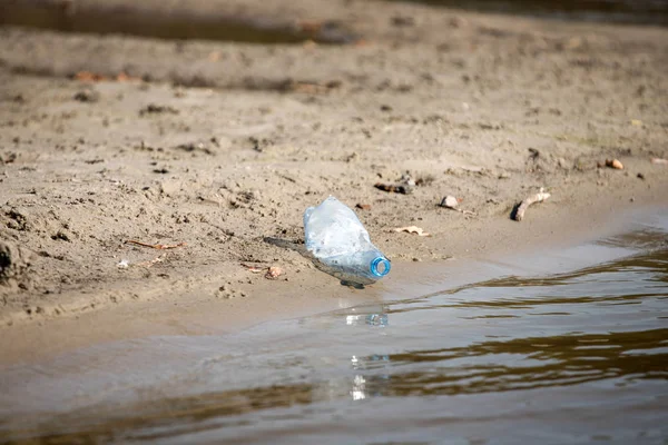 smashed pet disposable plastic bottle on beach sand. Plastic pollution