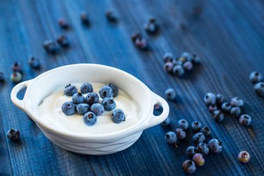ahşap arka planda Doğal yoğurt ile taze lezzetli Blueberry