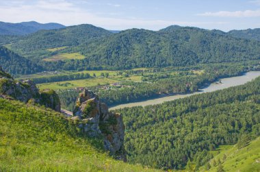 Yazın Altai nehri ve dağların arka planında taş kayalar.