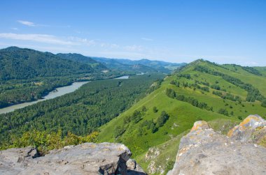 Yazın Altai nehri ve dağların arka planında taş kayalar.