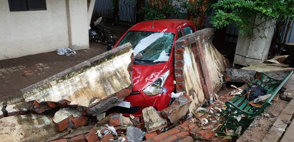 Carro destruído pela parede caída — Fotografia de Stock