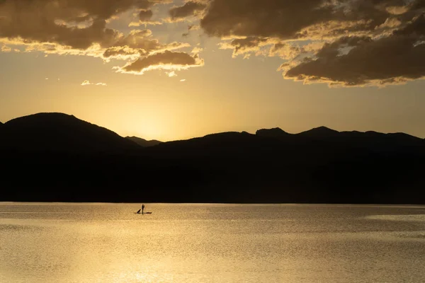位于科罗拉多州洛弗兰德市的一座高山湖上 一个人物形象的滑翔机带着他们的狗在夕阳西下 — 图库照片