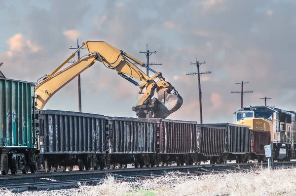 Escavadeira carregando velhos laços ferroviários em vagões abertos . — Fotografia de Stock