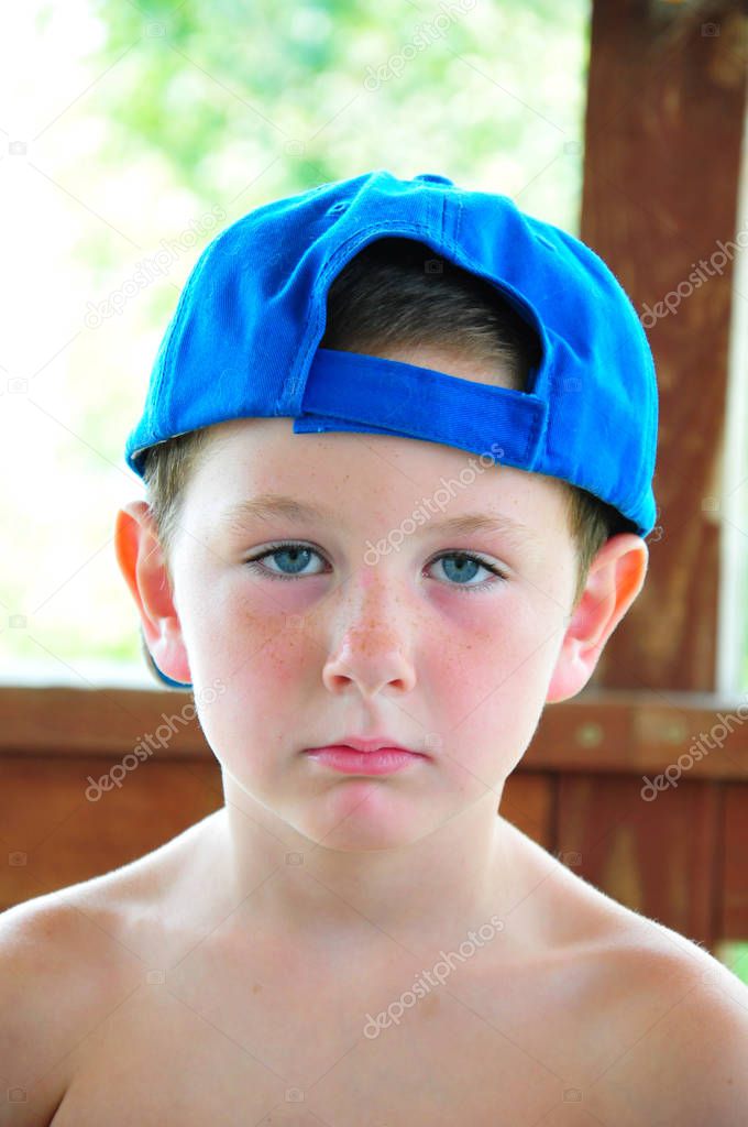Little boy resting with his hat sideways