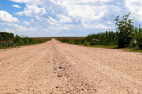 Uma estrada de cascalho que conduz ao horizonte — Fotografia de Stock