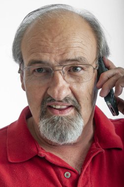 Kulağına cep telefonu dayanmış yaşlı bir adam.