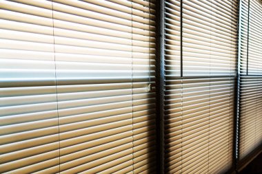 Güneş ışığı sabahın erken saatlerinde pencerenin perdelerine vuruyor.