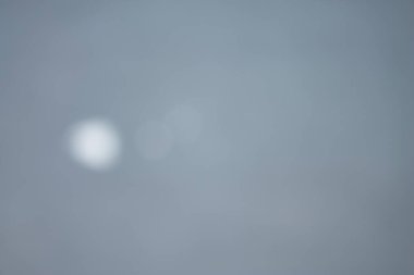 Tek bir yumuşak bokeh ışığı içeren sakin, serin gri soyut bir arkaplan. Ciddi ve profesyonel atmosfer kurumsal, teknolojik ya da tefekküre dayalı konular için mükemmeldir. Geniş kopyalama alanı tasarım için temiz bir tuval sağlar.