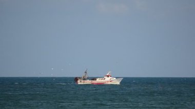 Barco pesquero pasando de izquierda a derecha