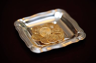 Arras de boda. Monedas de oro sobre bandeja de plata.