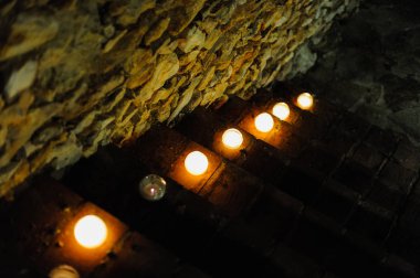 Escalones con lamparas en forma de esfera junto a muro de piedra de noche
