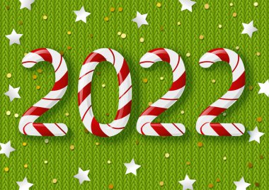 Yeni yıl konsepti - 2022 şeker sayısı yeşil örülmüş arka planda altın konfeti ve kış tatili tasarımında yıldızlar