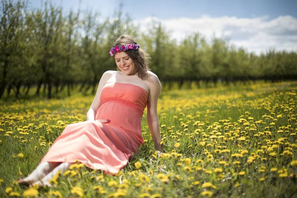 Krásná Těhotná Žena Jarní Zahradě Mezi Rozkvetlé Pampelišky — Stock fotografie