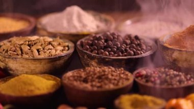 Mutfak masasında çeşitli baharatlar ve otlar var.