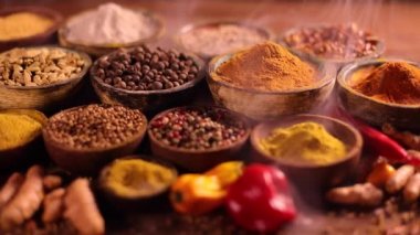 Mutfak masasında çeşitli baharatlar ve otlar var.