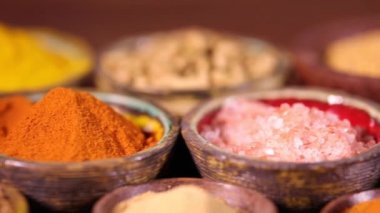 Mutfak masasında çeşitli baharatlar ve otlar var.