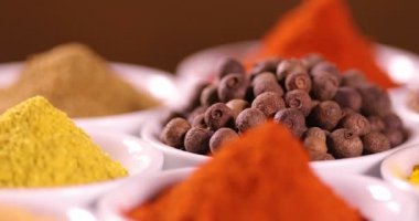 Mutfak masasında çeşitli baharatlar ve otlar var.