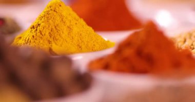 Mutfak masasında çeşitli baharatlar ve otlar var.