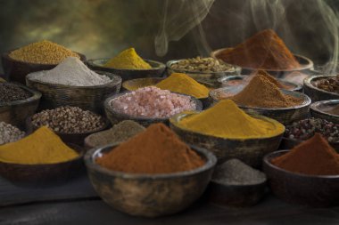 Mutfak masasında çeşitli baharat ve bitkiler var.