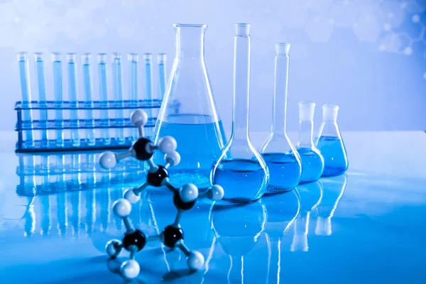 Laboratuvar deney tüpleri, fen deneyleri, mavi arka plan.