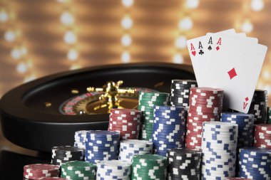 Kumar masasında poker fişleri, hareket halindeki rulet çarkı, kumarhane geçmişi