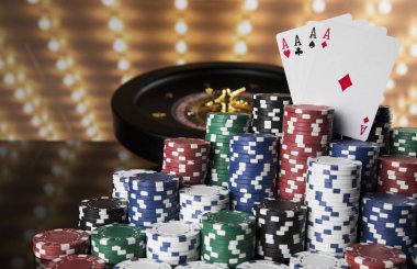 Kumar masasında poker fişleri, hareket halindeki rulet çarkı, kumarhane geçmişi