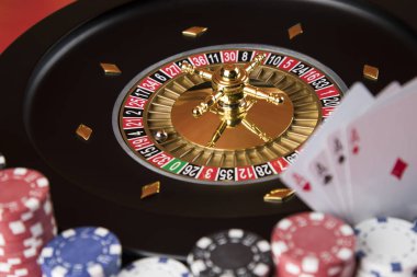 Kumar masasında poker fişleri, hareket halindeki rulet çarkı, kumarhane geçmişi