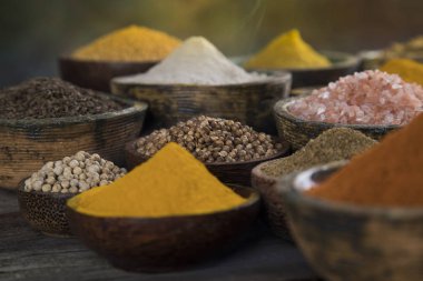 Mutfak masasında çeşitli baharat ve bitkiler var.