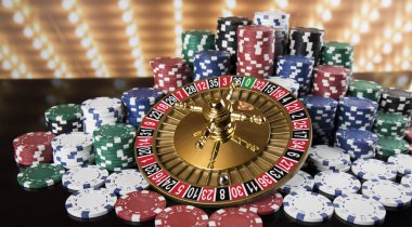 Kumar masasında poker fişleri, hareket halindeki rulet çarkı, kumarhane geçmişi