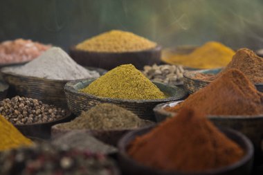 Mutfak masasında çeşitli baharat ve bitkiler var.