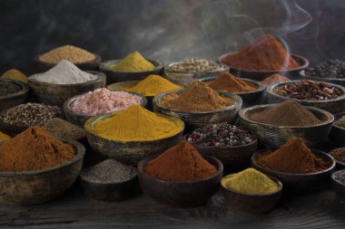 Mutfak masasında çeşitli baharat ve bitkiler var.